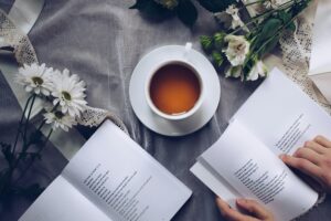 A cup of tea resting on an open journal, representing gentle approaches to procrastination and self-care.